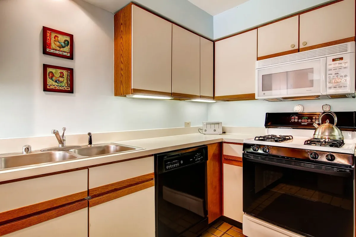 A functional and inviting kitchen area, complete with modern appliances including a stove, kitchen sink, and microwave. Decorative wall art adds a cozy touch, and the space is organized for efficient meal prep, ideal for both quick breakfast routines and preparing hearty feasts.