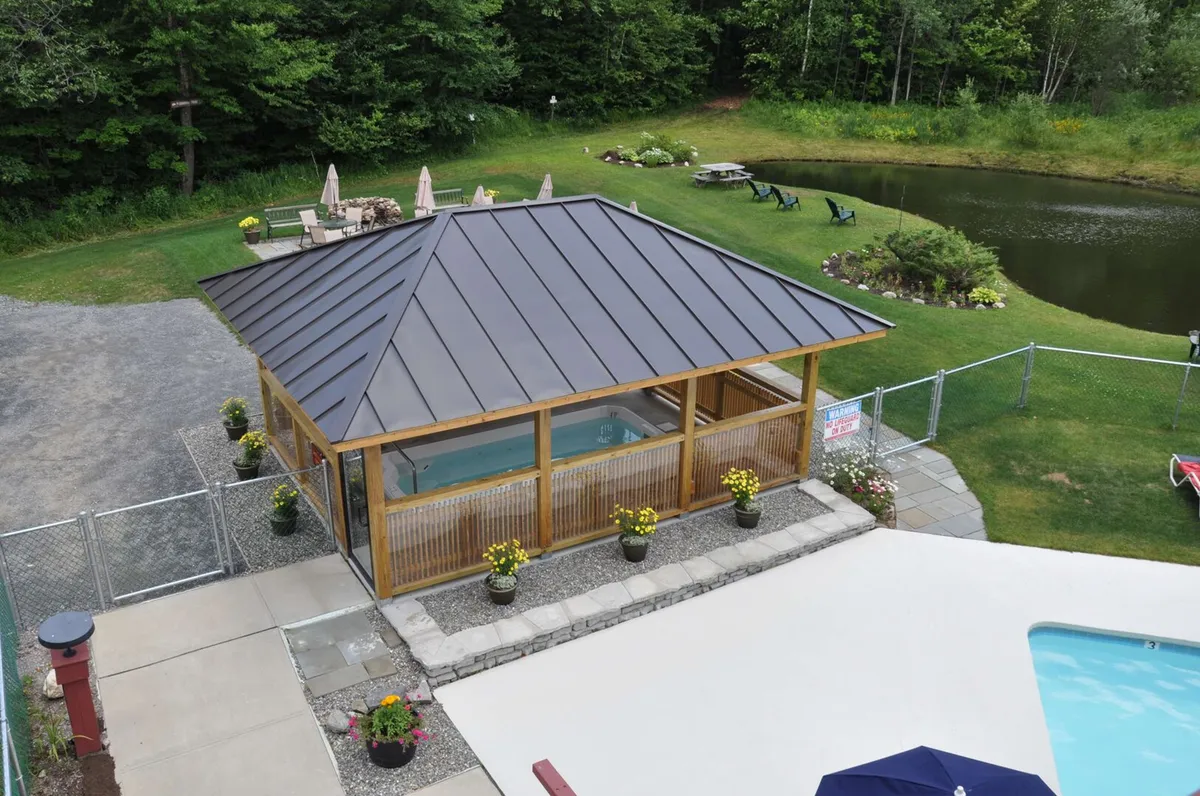 A peaceful setting featuring a gazebo, swimming pool, pond, and landscaped gardens. The view invites relaxation or picnics by the water, as well as quiet moments spent in nature with soft sunset lighting.
