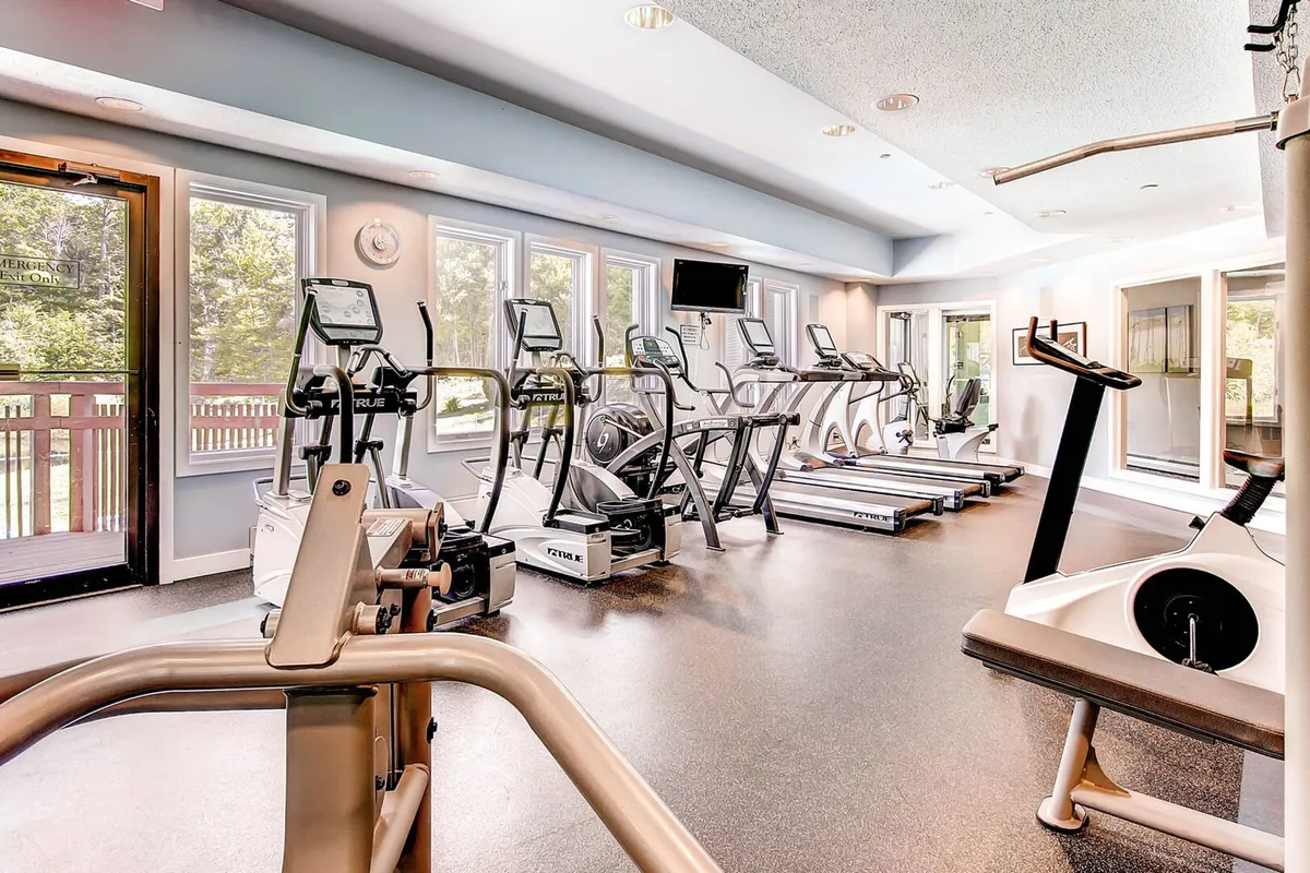 A bright, modern fitness center with various exercise equipment and large windows that let in ample natural light. The area looks motivating and spacious, ideal for starting the day with a workout or maintaining fitness routines while traveling.