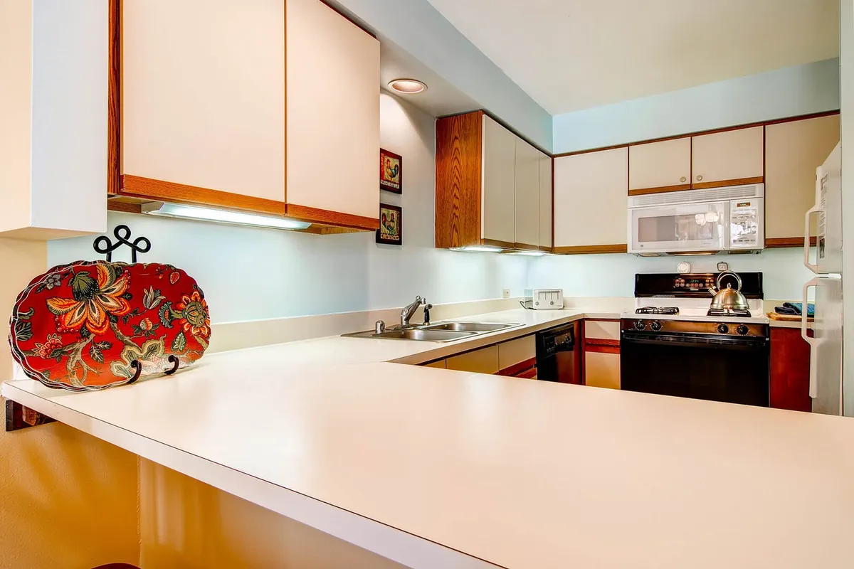 A welcoming kitchen scene showcasing decorative plates, modern kitchen appliances, and generous counter space. The ambiance is warm and inviting, encouraging both cooking and socializing. Practicality meets style, making it easy to prepare meals or snacks for any occasion.